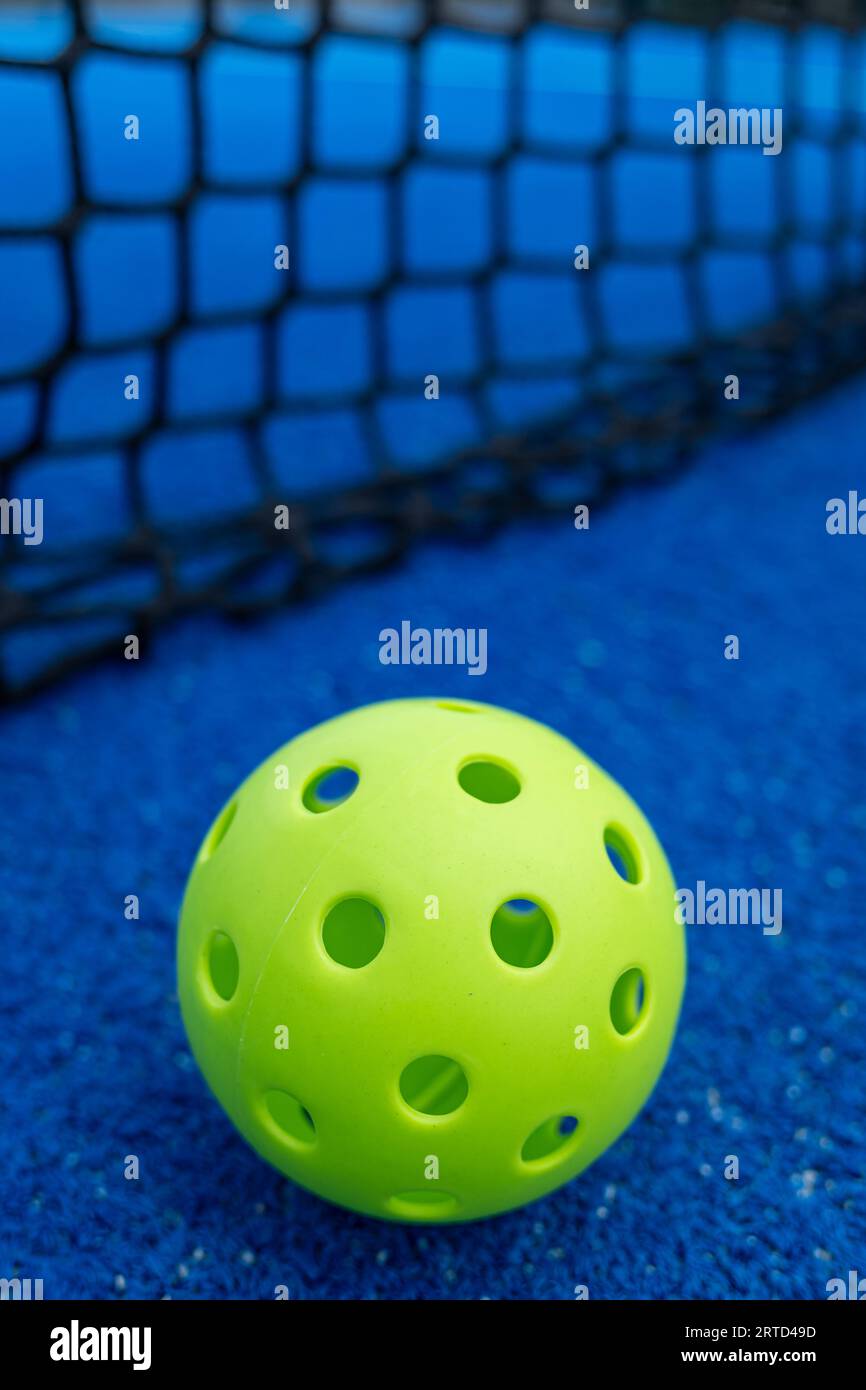 Selective focus. A pickleball ball near the net in a blue court Stock Photo