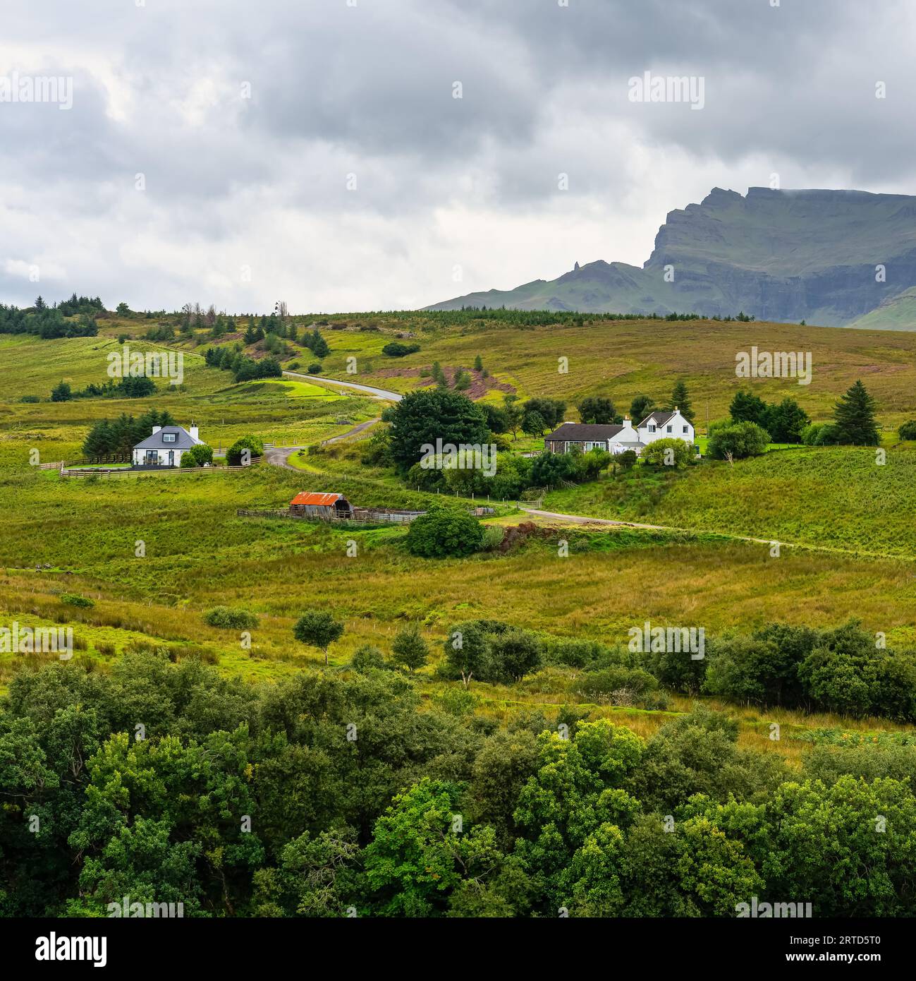 Green landscape with high mountains and cottages on the Isle of Skye ...