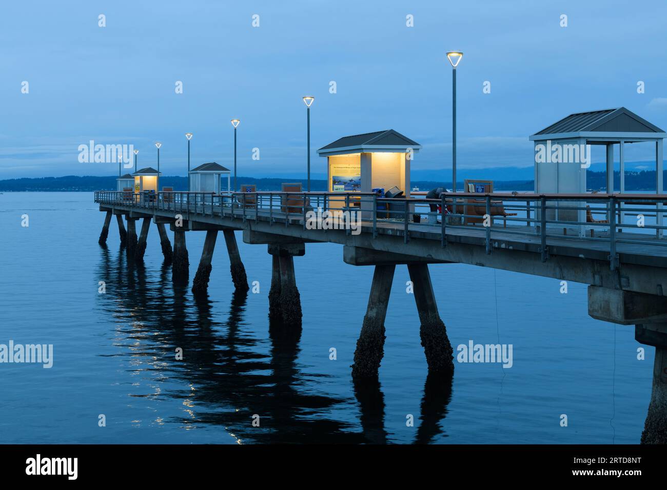 Edmonds, WA, USA - September 11, 2023; Blue hour morning on the Edmonds Fishing Pier with warm glow of lights Stock Photo