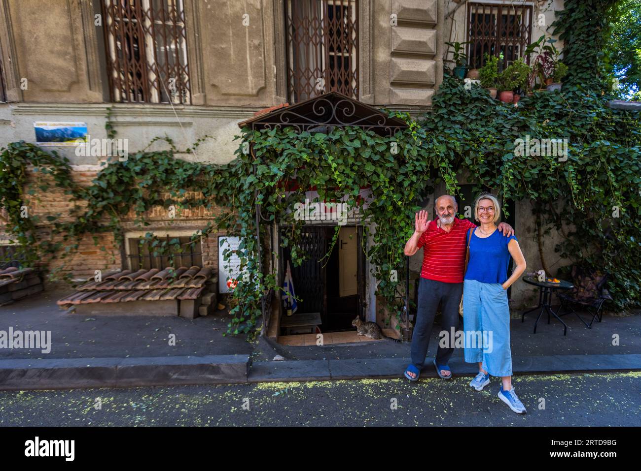 Two people outside the entrance to the Nikolozi restaurant in Tbilisi, Georgia (34 Anton-Katalikosi Street). The ivy-covered historic building houses the restaurant, which is known for its home-cooked Georgian cuisine, a handwritten menu and the fact that it accepts cash only. Anton Katalikos Street, Kala, Ortachala, Krtsanisi District, Tbilisi, 0108, Georgia Stock Photo