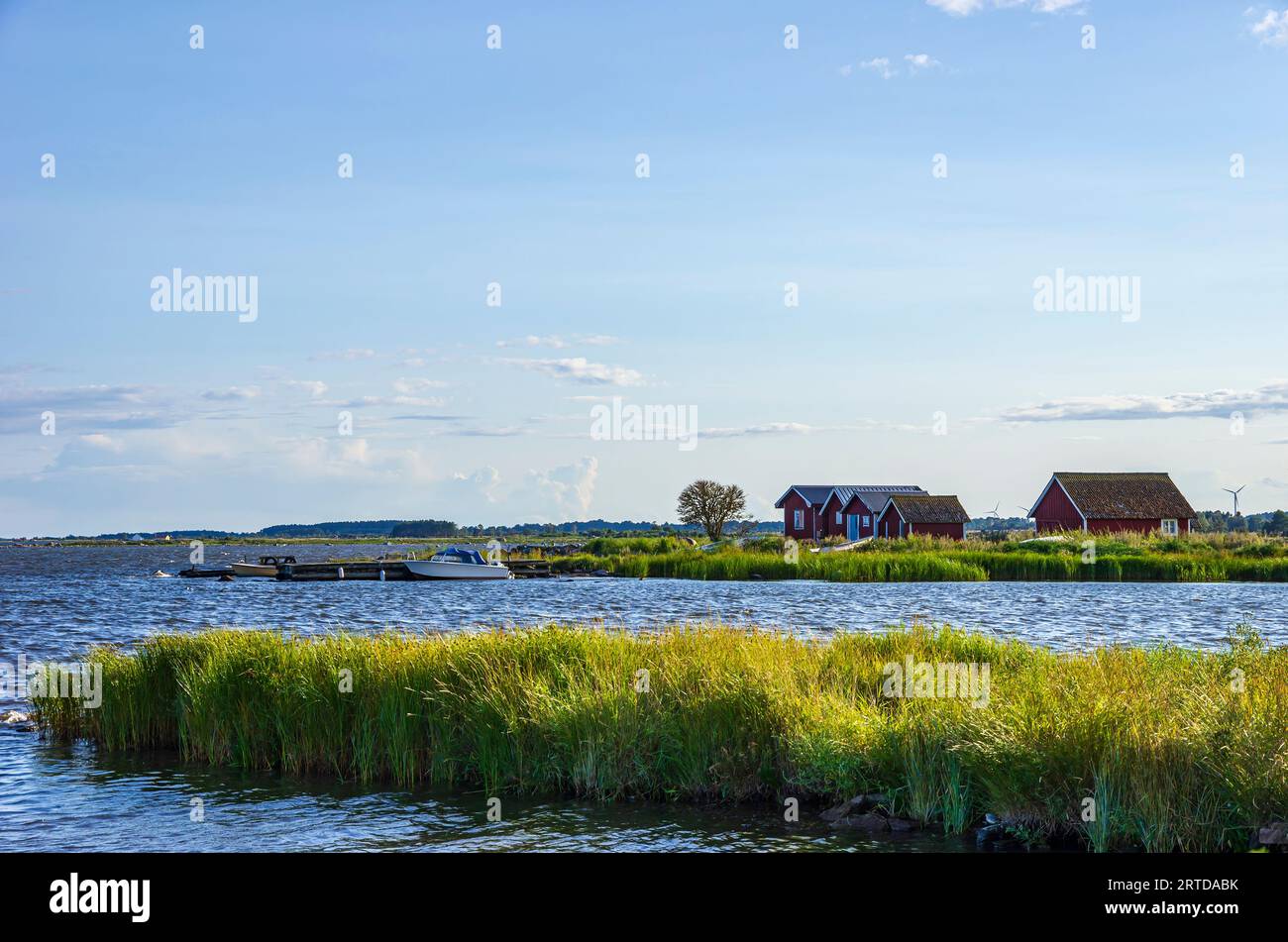 Idyllic seaside scenery of cabins and boats in the evening light on Oland Island, Sweden. Stock Photo