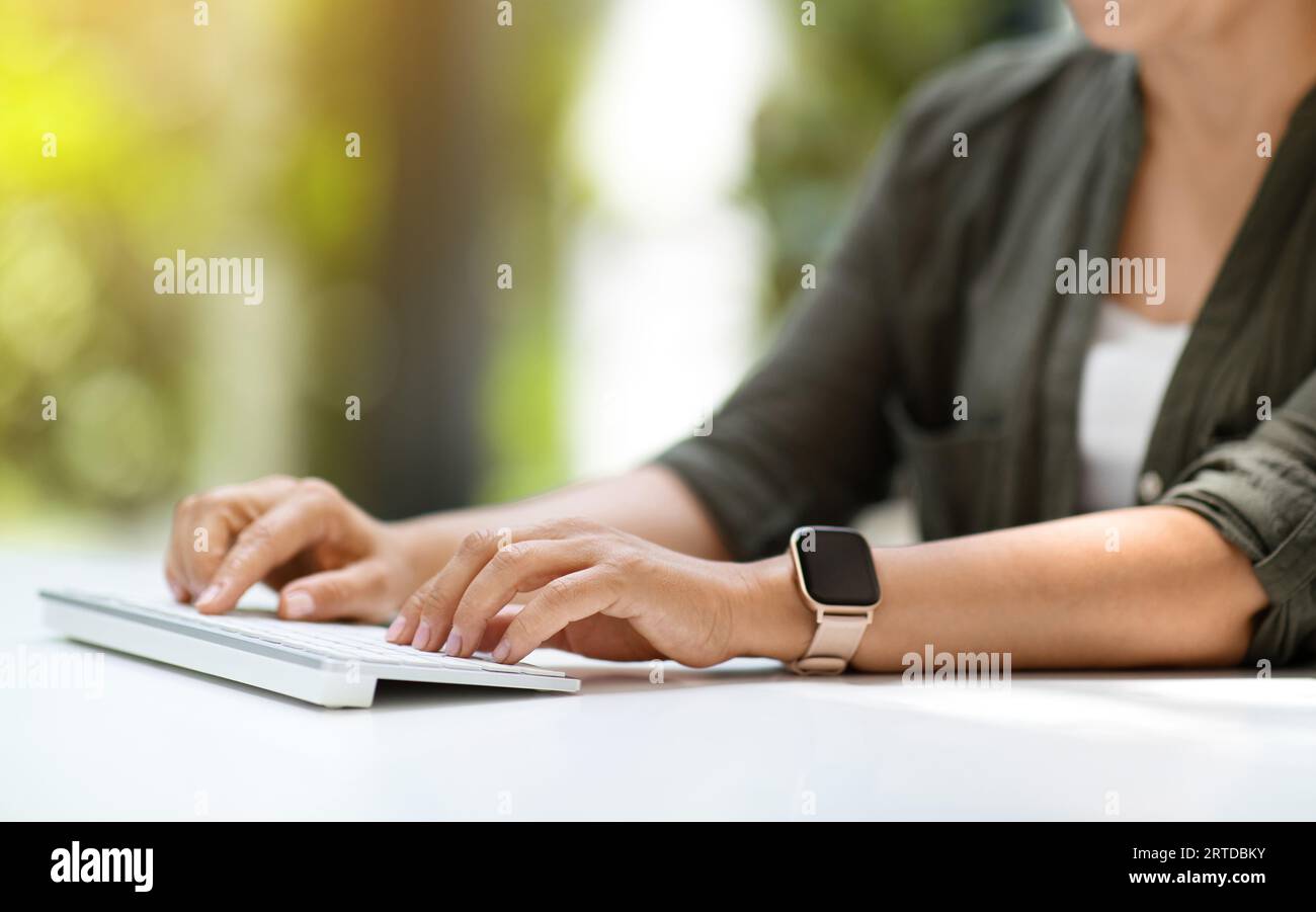 Unrecognizable woman typing on wireless computer keyboard Stock Photo