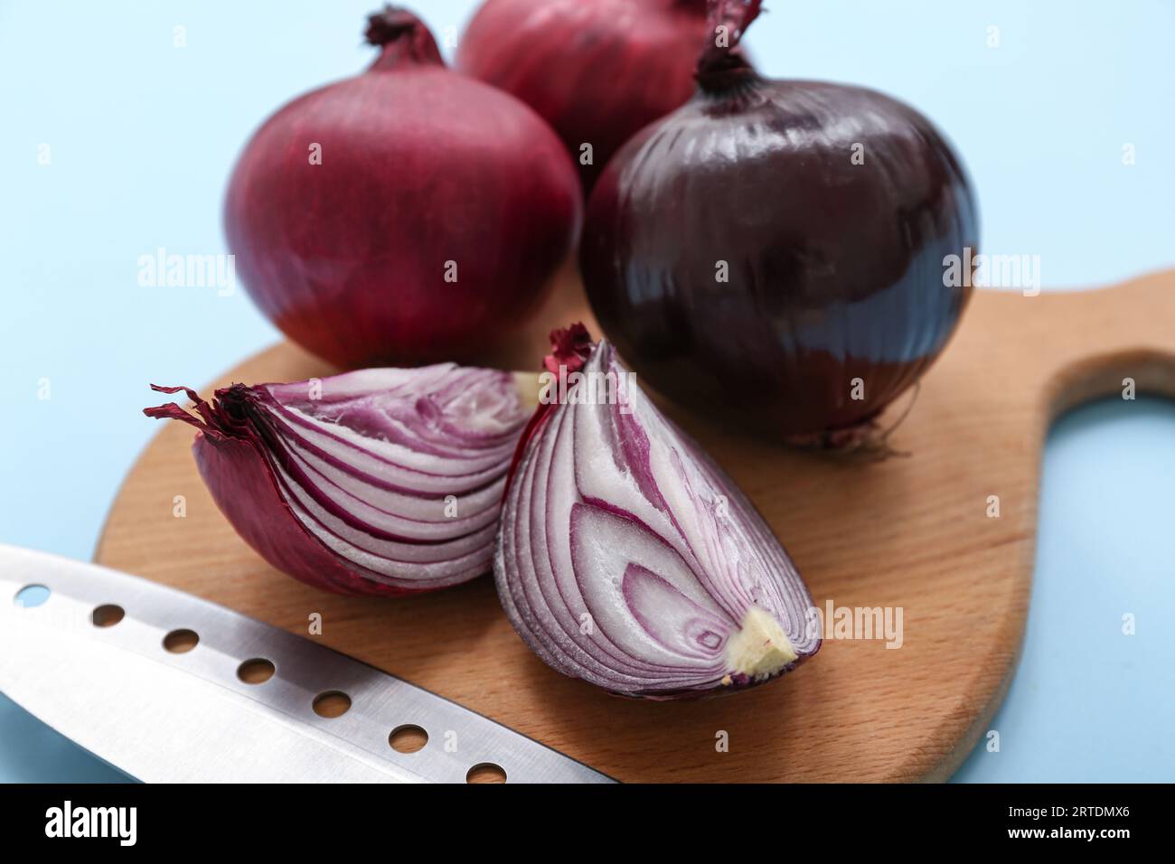 Wooden board with fresh red onions on blue background Stock Photo - Alamy