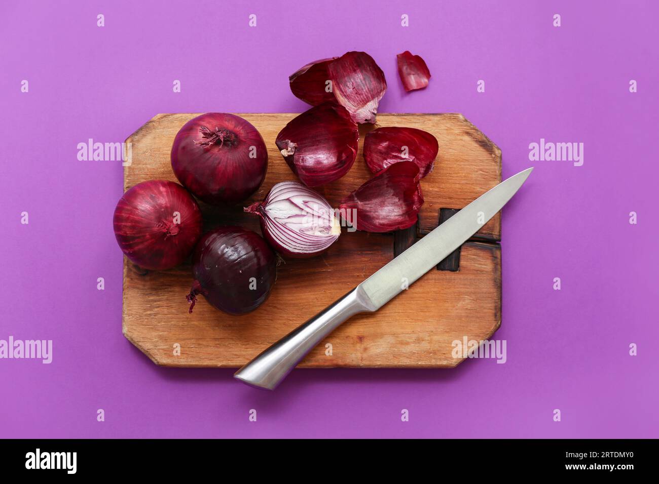 Wooden board with fresh red onions on purple background Stock Photo - Alamy