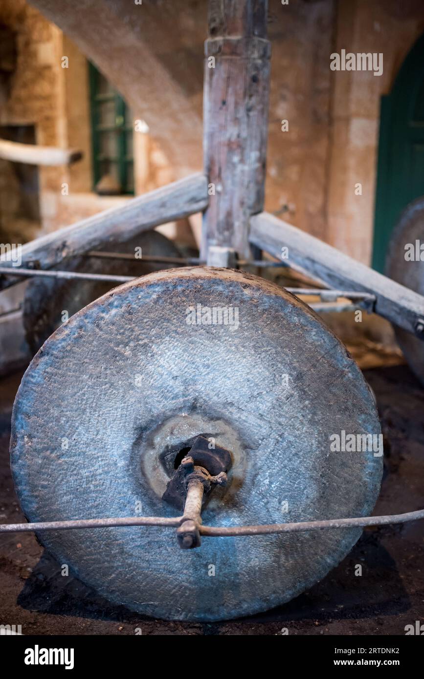 A stone wheel used in an olive press machine to produce olive oil. Stock Photo