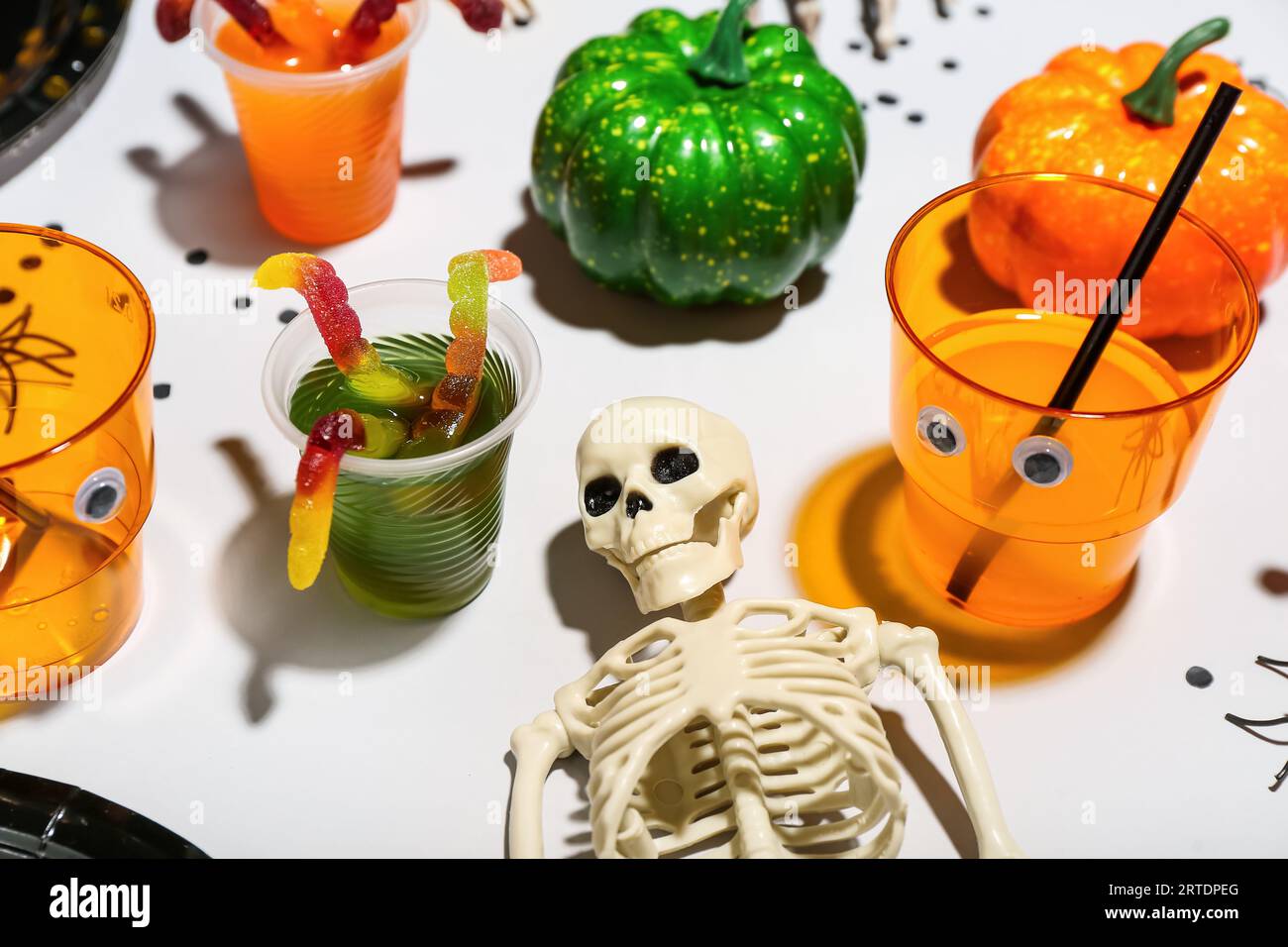 Skeleton Punch Halloween party table setting with punch, skeleton and gummy worms on ...