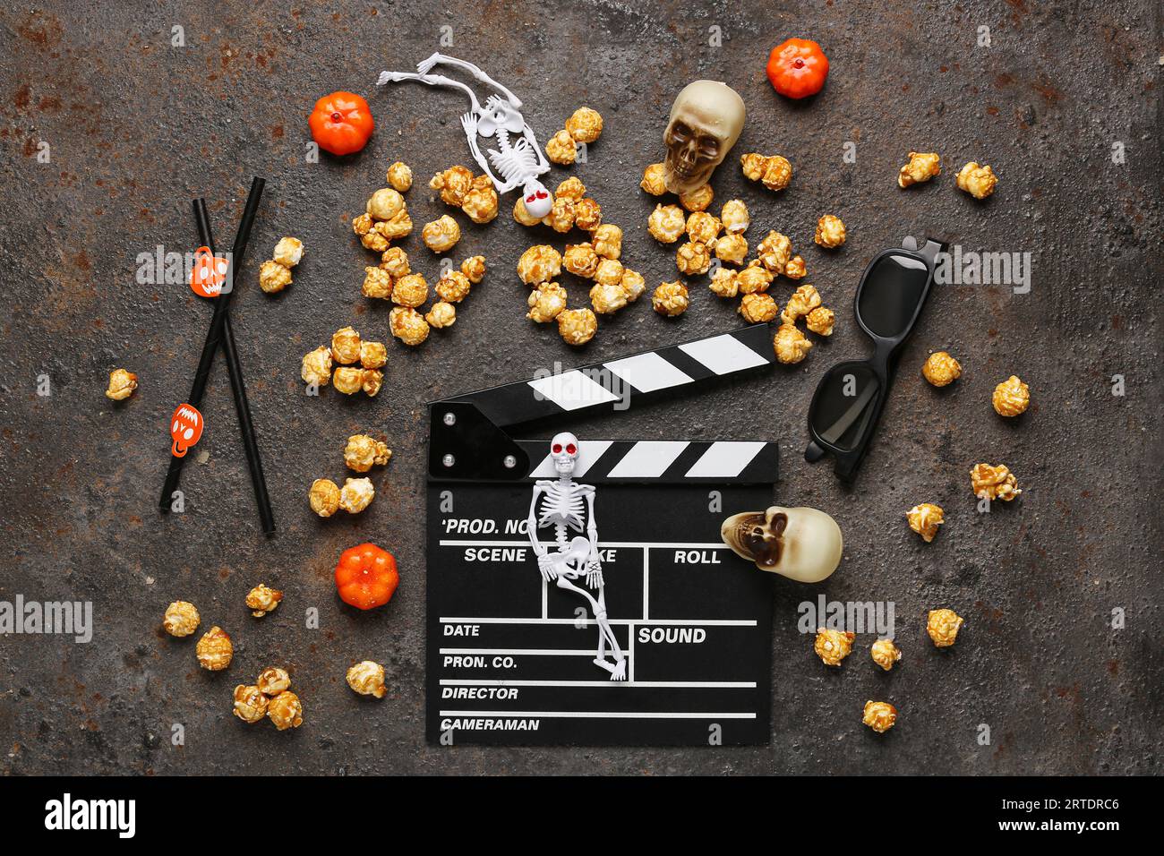 Movie clapperboard, caramel popcorn and Halloween decor on grunge background Stock Photo