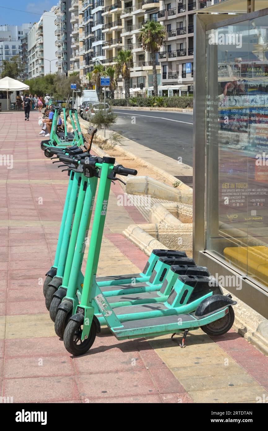Sliema, Malta - 6 August 2023: Row of electric scooters for rent parked in a row on the promenade in Sliema Stock Photo