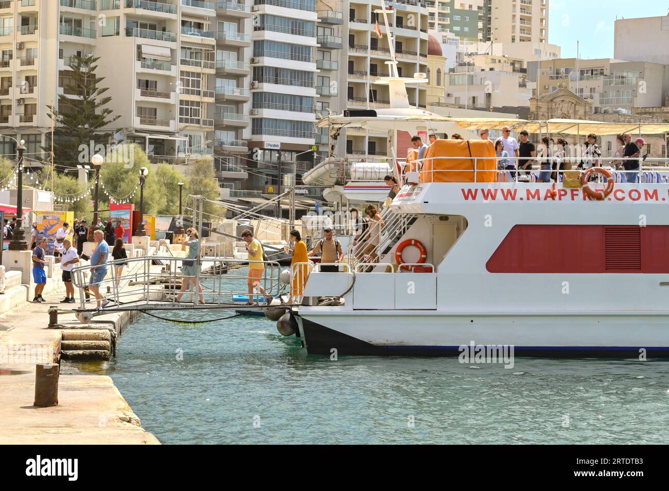 Sliema, Malta - 6 August 2023: Passengers getting off a small ferry in Sliema after arriving from the island's capital, Valletta. Stock Photo