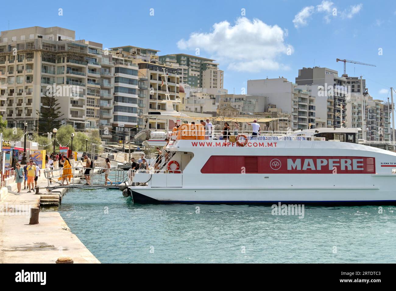 Sliema, Malta - 6 August 2023: Passengers getting off a small ferry in Sliema after arriving from the island's capital, Valletta. Stock Photo