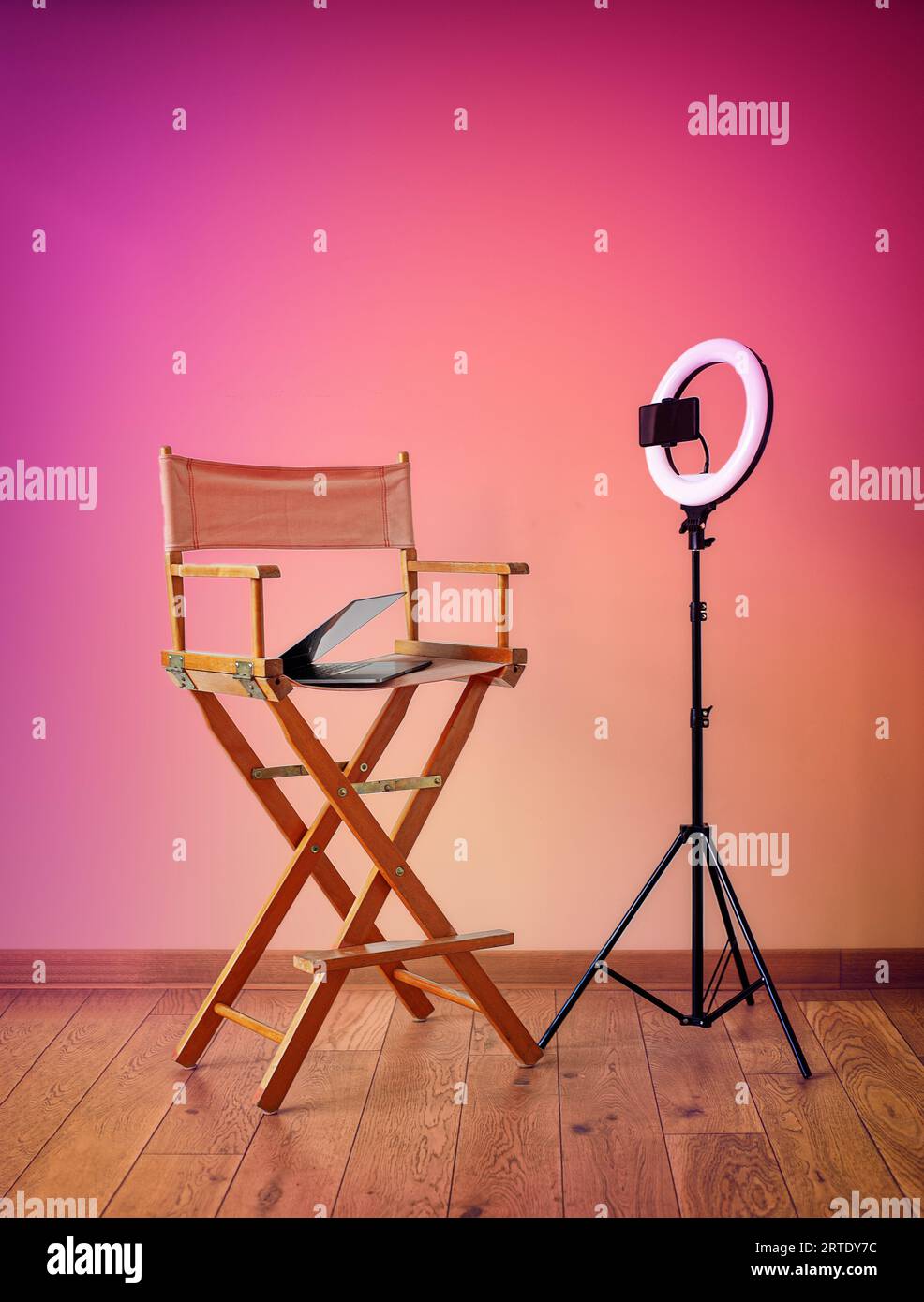 Director's chair, ring lights, digital camera with laptop and hats on colorful background with recording equipment Stock Photo