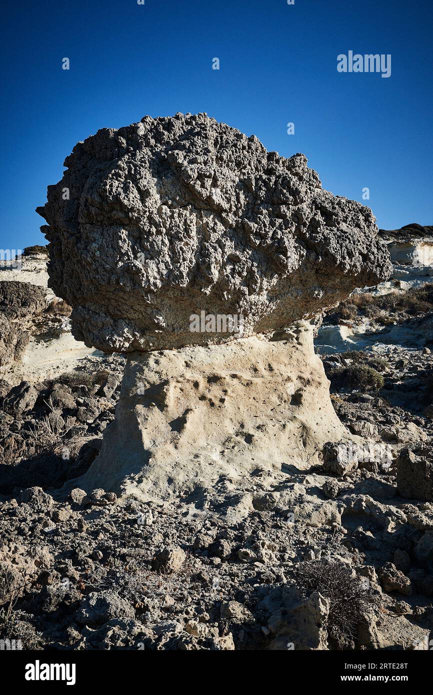 Mushroom shaped Erosion resistant boulder perched on pillar of tuff in Sarakiniko, Milos, Cyclades, Greece Hellas Greek islands Stock Photo