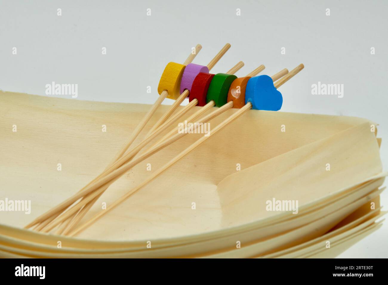 Environmentally friendly disposable Wooden Serving Boats with Wooden food picks and Colourful Hearts Stock Photo