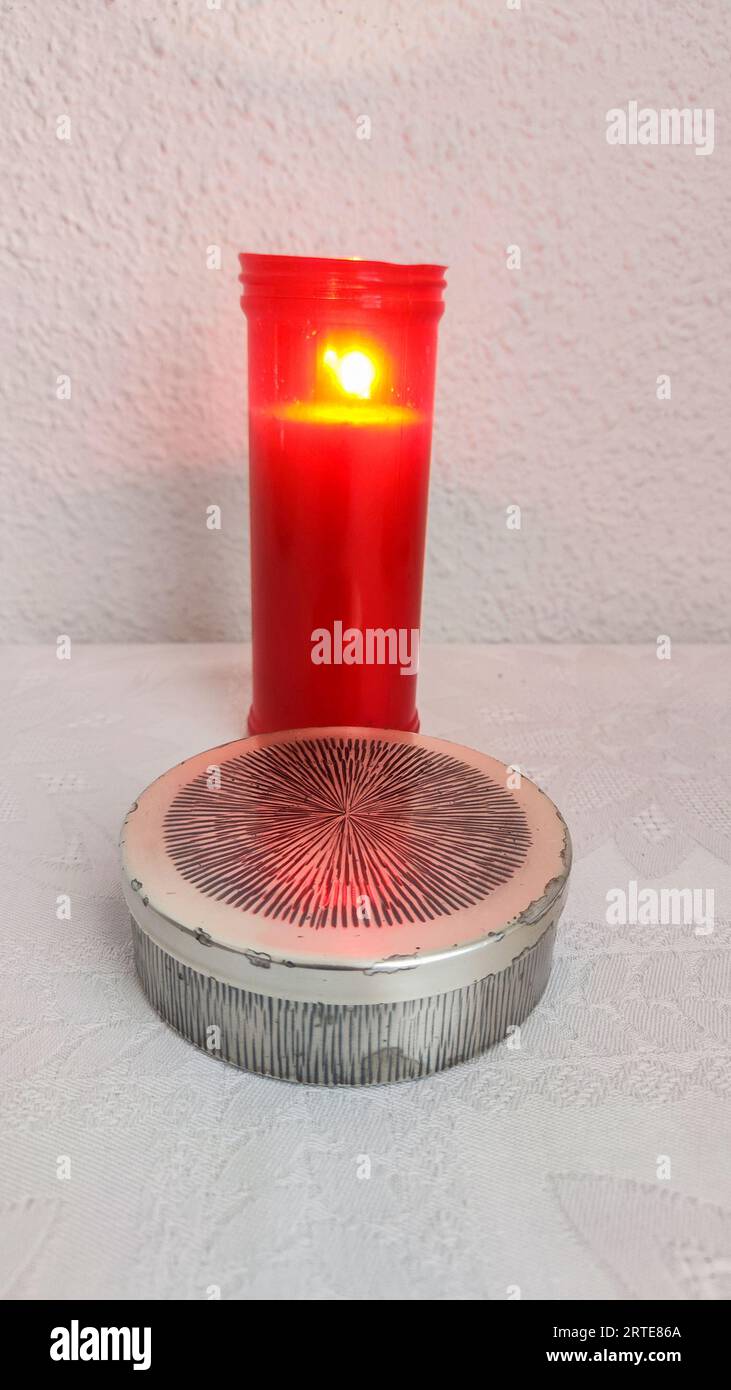 lighted candle for the Most Holy Body of Christ in a teak or teak box