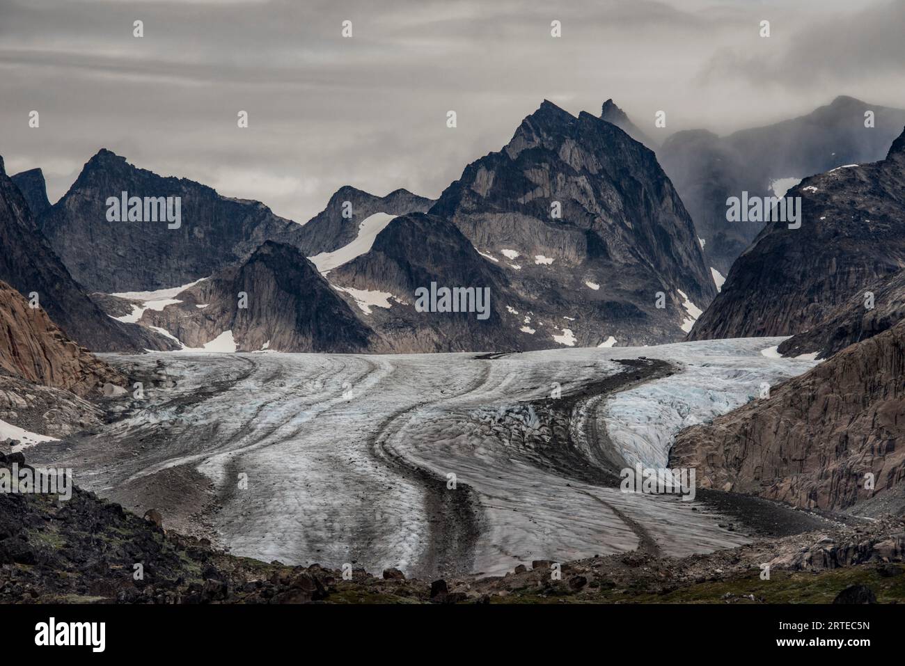 View of glacier flowing through the mountain peaks in Prins Christian Sund at the Southern tip of Greenland; Southern Greenland, Greenland Stock Photo