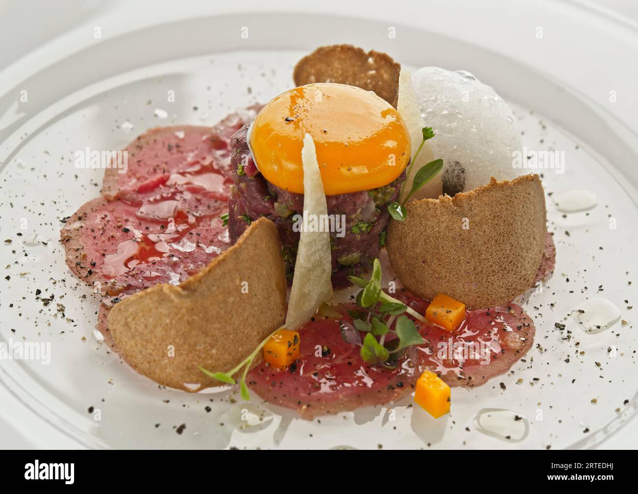 Carpaccio of Black Angus beef with egg yolk, parmesan and crackers Stock Photo