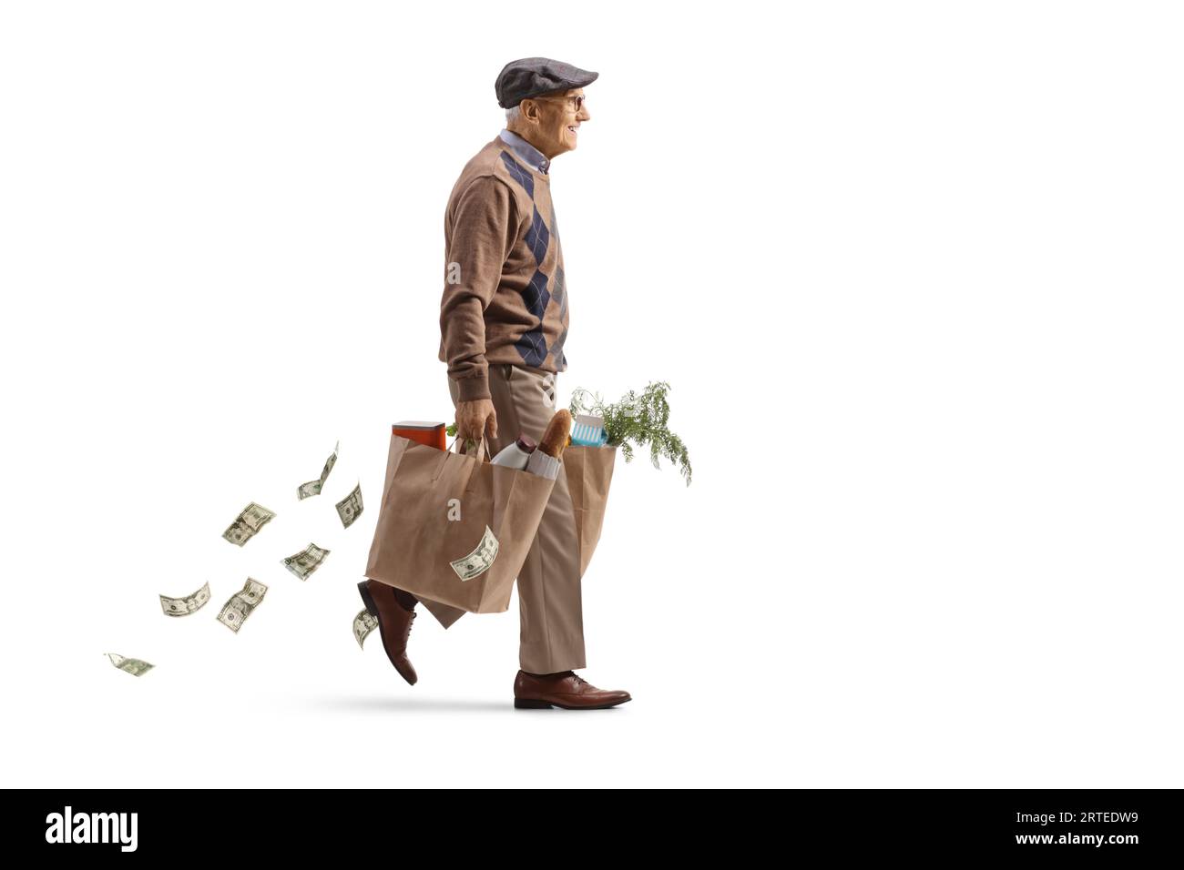 Full length profile shot of an elderly man carrying grocery bags and losing money isolated on white background Stock Photo