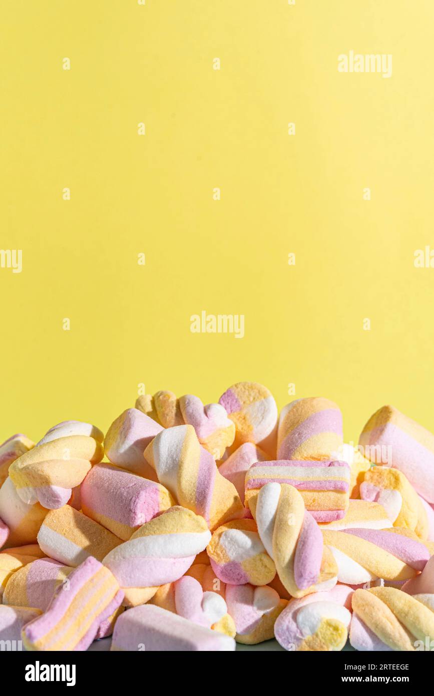 Colourful marshmallows against a yellow background Stock Photo