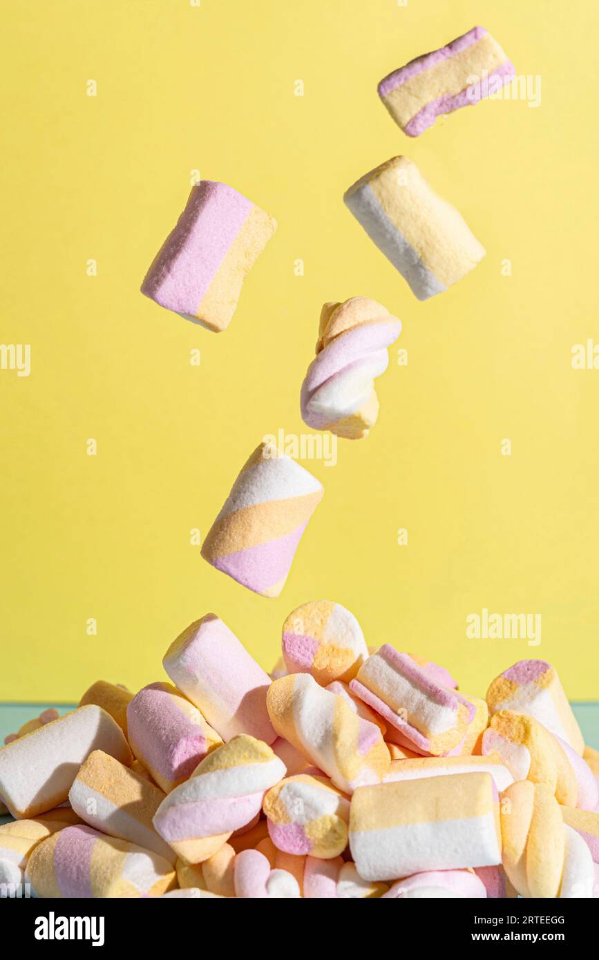 Flying marshmallows against a yellow background Stock Photo