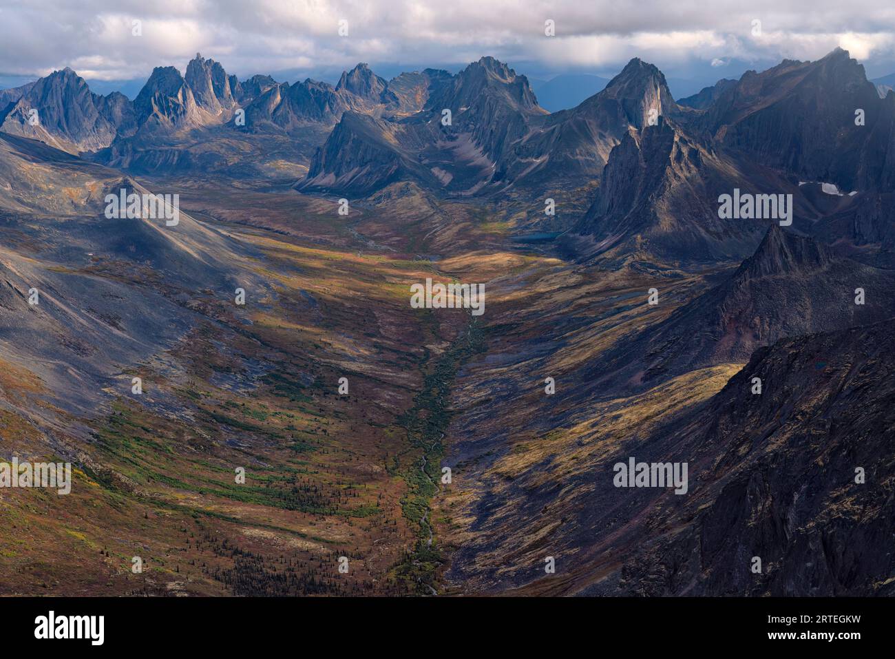 Aerial view of rugged mountain peaks and a valley with tundra in autumn ...