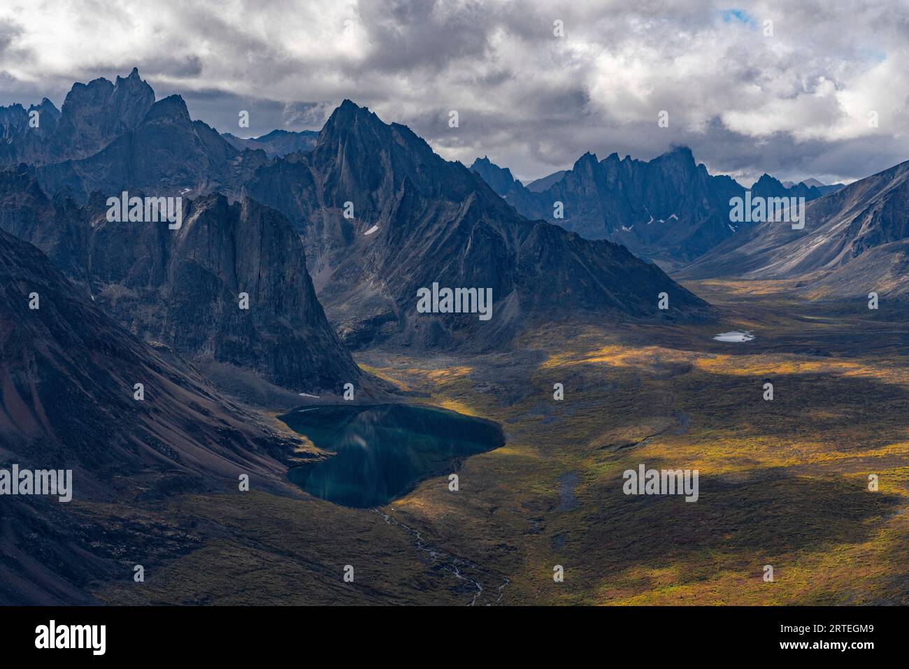 Aerial view of rugged mountain peaks and a valley with tundra in autumn ...