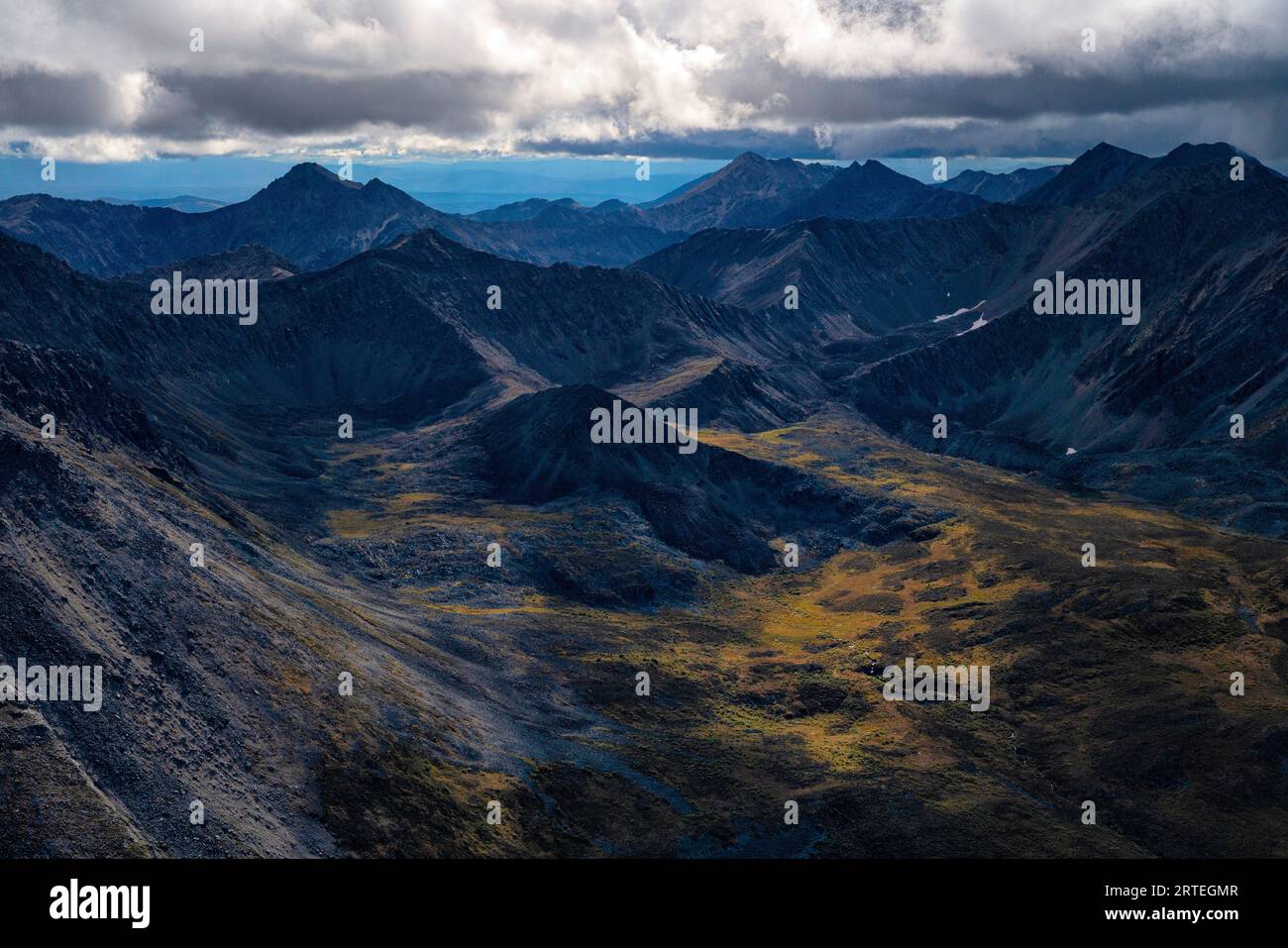 Aerial view of rugged mountain peaks and a valley with tundra in autumn ...