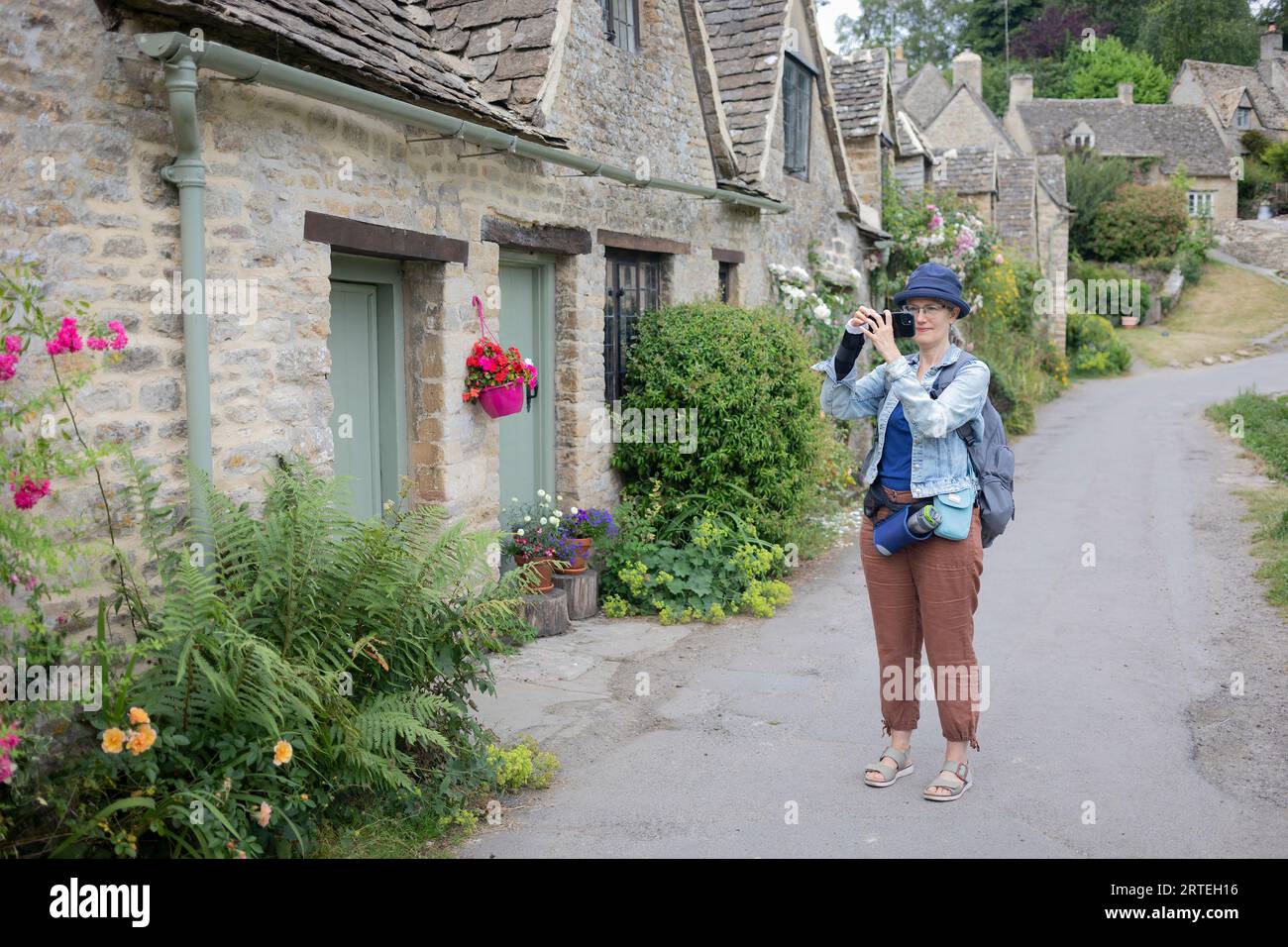 Mature woman uses her smart phone to take photographs while travelling in the UK; United Kingdom Stock Photo