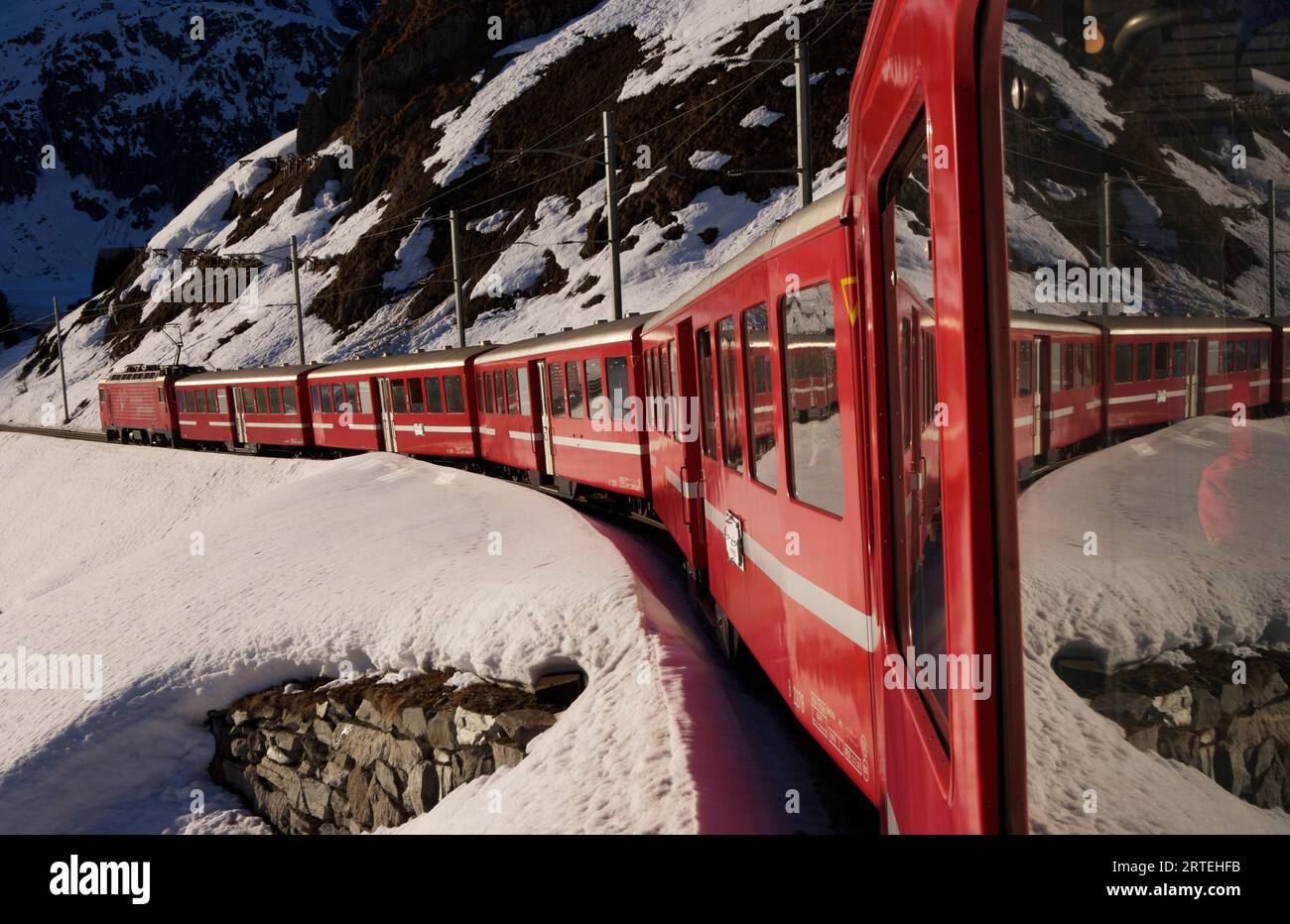 Glacier Express train in the Swiss Alps between Sedrun and Andermatt; Andermatt, Switzerland Stock Photo