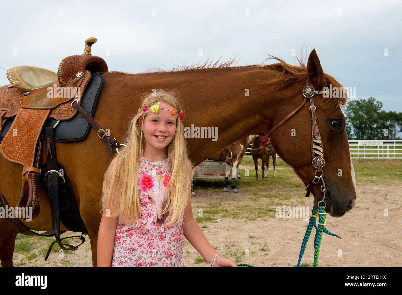Pre-adolescent girl stands next to her horse; Burwell, Nebraska, United States of America Stock Photo