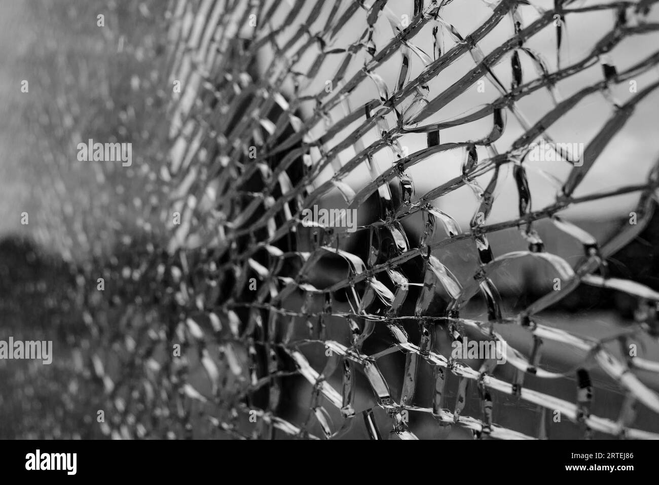 Black and white tone, Selective focus, broken crack glass window and blur background of the city and sidewalk. Stock Photo