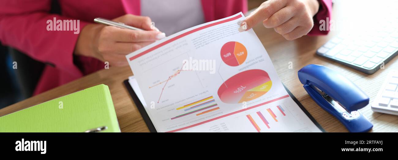 Manager working with financial reports while sitting at table in office. Stock Photo