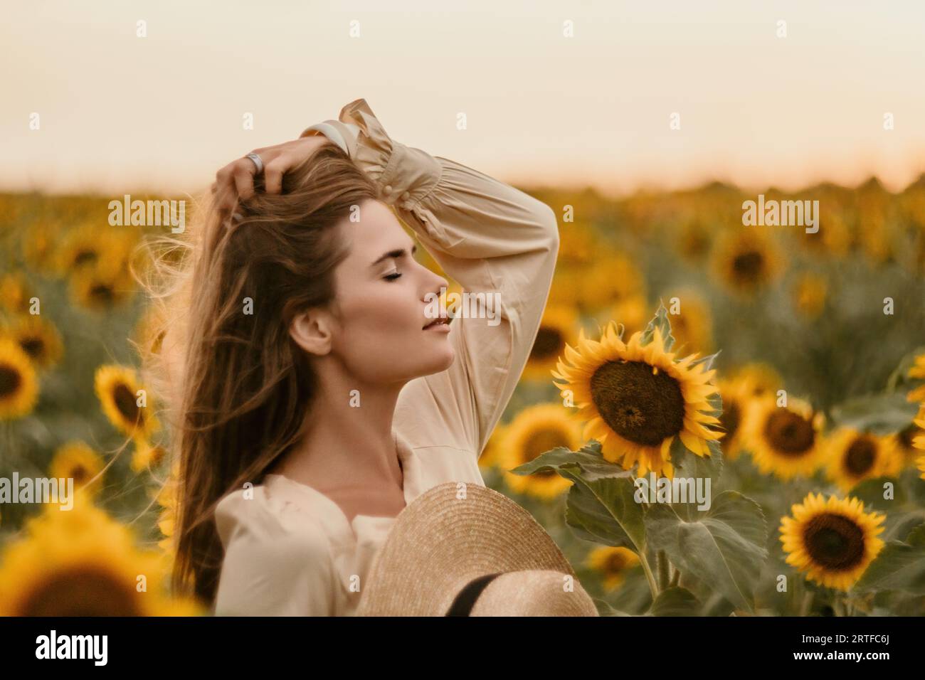 Woman in Sunflower Field: Happy girl in a straw hat posing in a vast ...