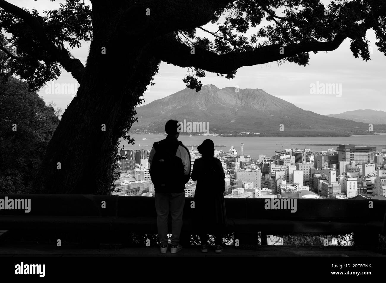 Kagoshima, Japan. 13th Mar, 2023. Tourists observing Sakurajima (æ¡œå³¶), an active stratovolcano along the Pacific Rim of Fire, erupting a cloud of volcanic ash with the major metropolitan urban city of Kagoshima in the foreground at night.Sakurajima is heavily monitored by the Japan Meteorological Agency and is on the United Nations' Decades Volcano list. It is one of the 16-most active volcanoes posing as major natural disaster risk to populated cities. (Credit Image: © Taidgh Barron/ZUMA Press Wire) EDITORIAL USAGE ONLY! Not for Commercial USAGE! Stock Photo