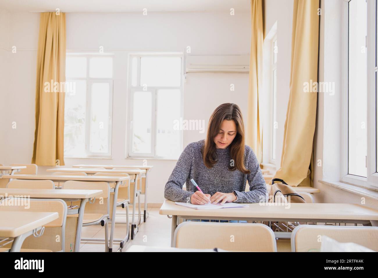 Girl Alone In Classroom Making Notes Stock Photo Alamy Girl Alone In Classroom Making Notes Stock Photo Alamy