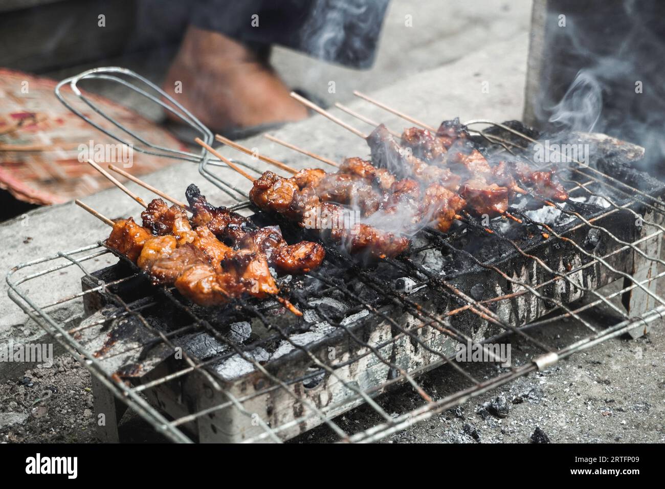 Top view of Sate or satay, traditional food from Indonesia is being grilled on fiery charcoal. Stock Photo