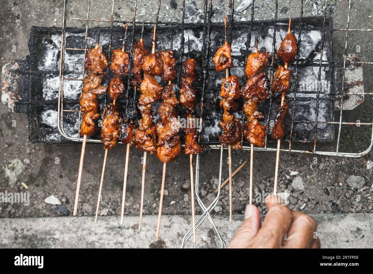 Top view of Sate or satay, traditional food from Indonesia is being grilled on fiery charcoal. Stock Photo