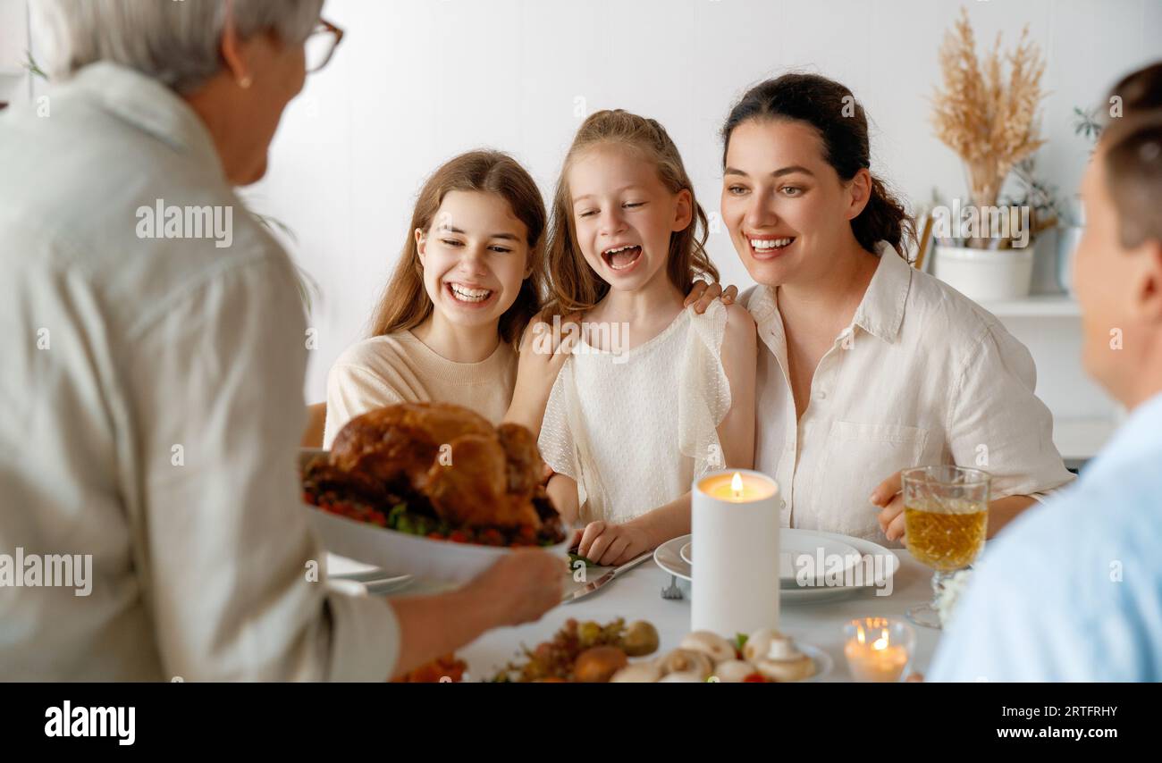 Thanksgiving Day, Autumn feast. Happy family sitting at the table and