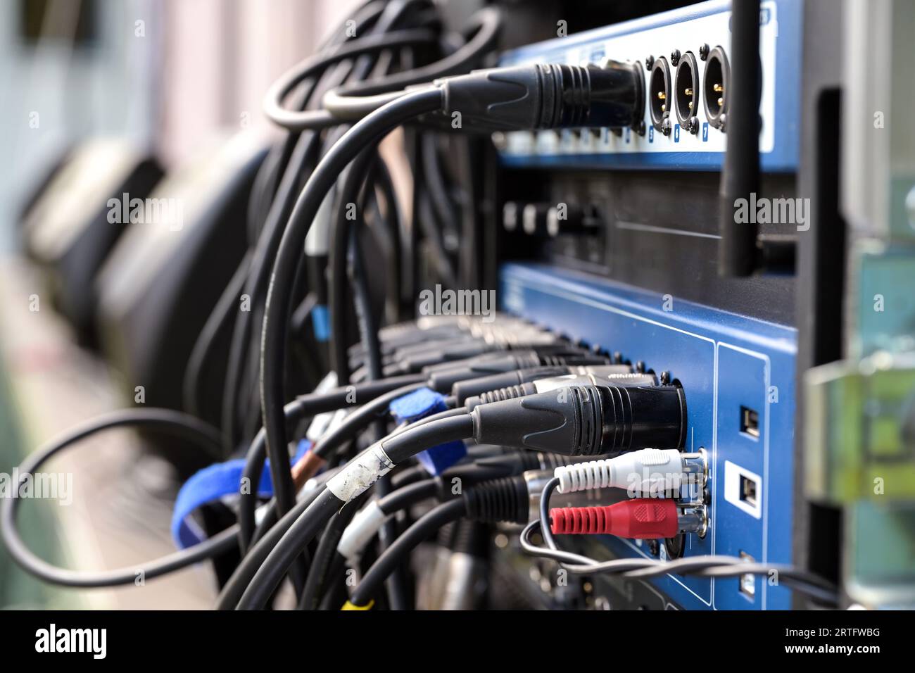 Many cables plugged into the sound mixer console at a music festival, copy space, selected focus, narrow depth of field Stock Photo