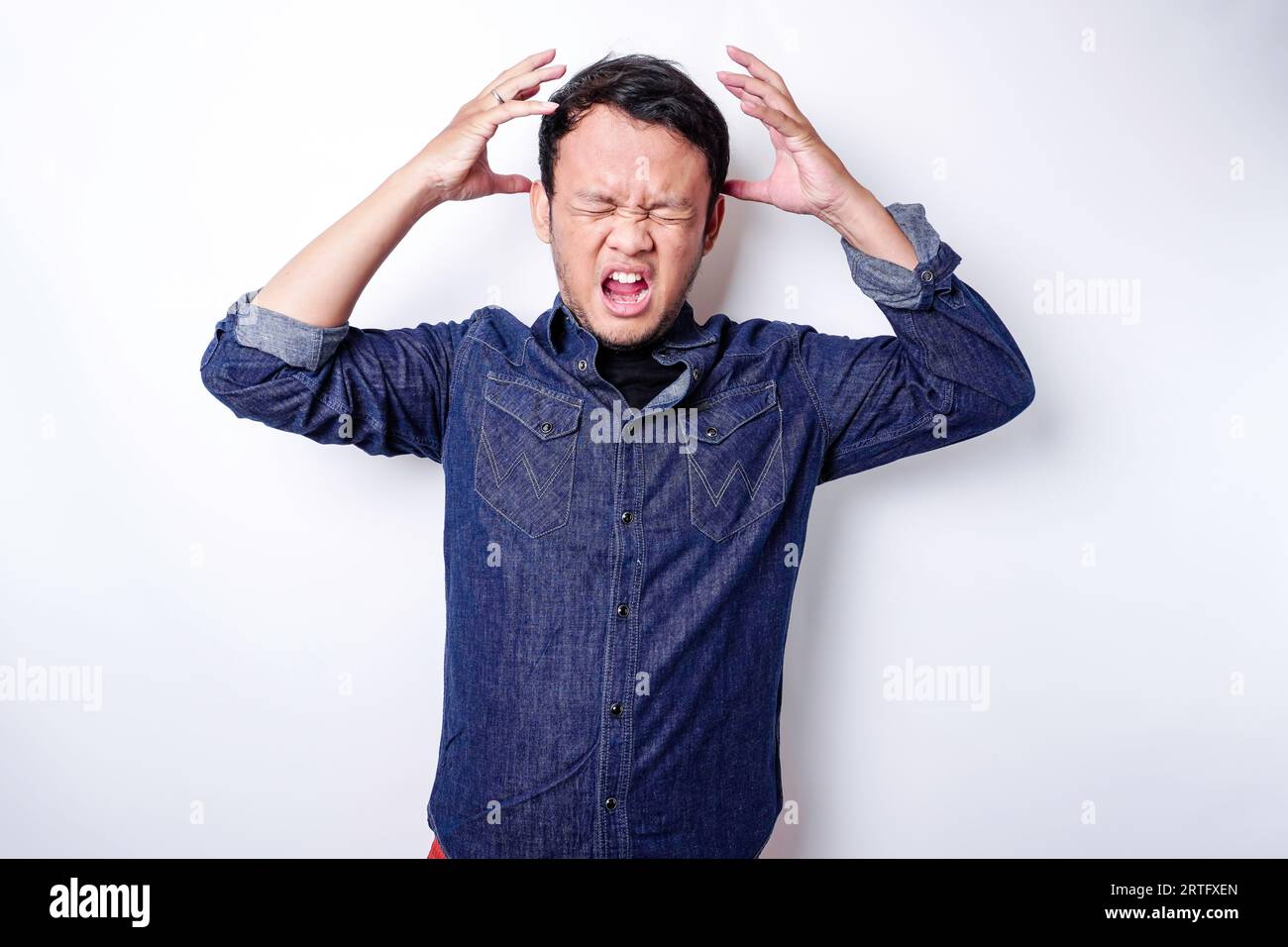 The angry and mad face of Asian man in blue shirt isolated white ...