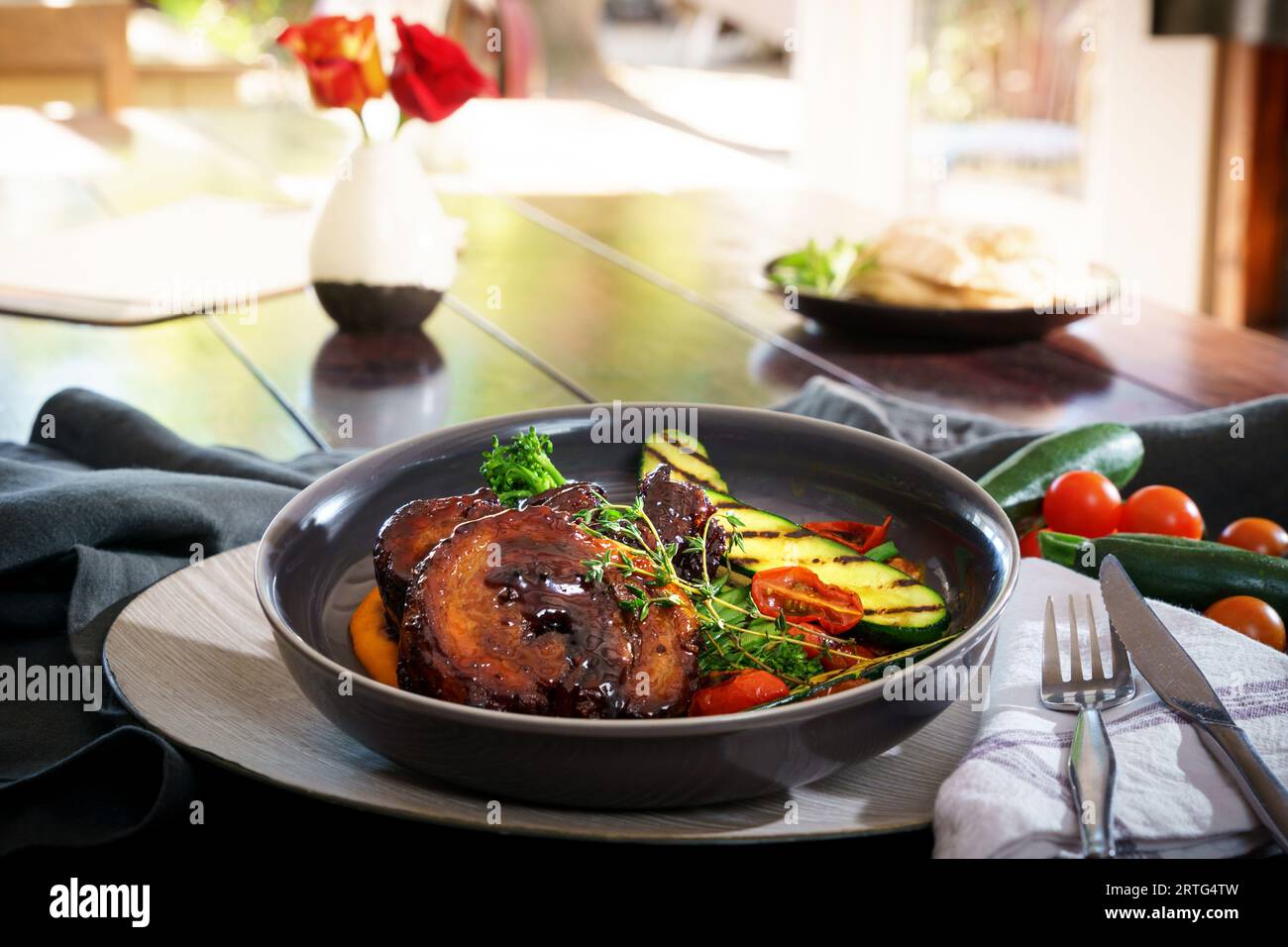 pork belly meal plated for serving showing garnishings and a setting Stock Photo