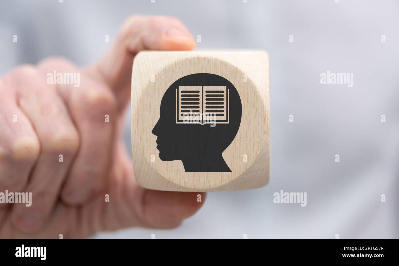 Hand holding a wooden cube with symbol of knowledge concept Stock Photo ...