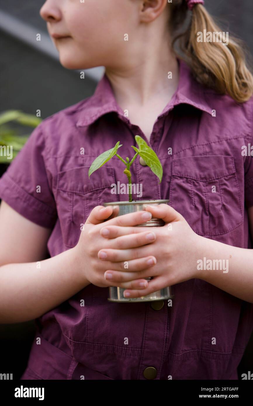 Close up of young girl holding a plant Stock Photo