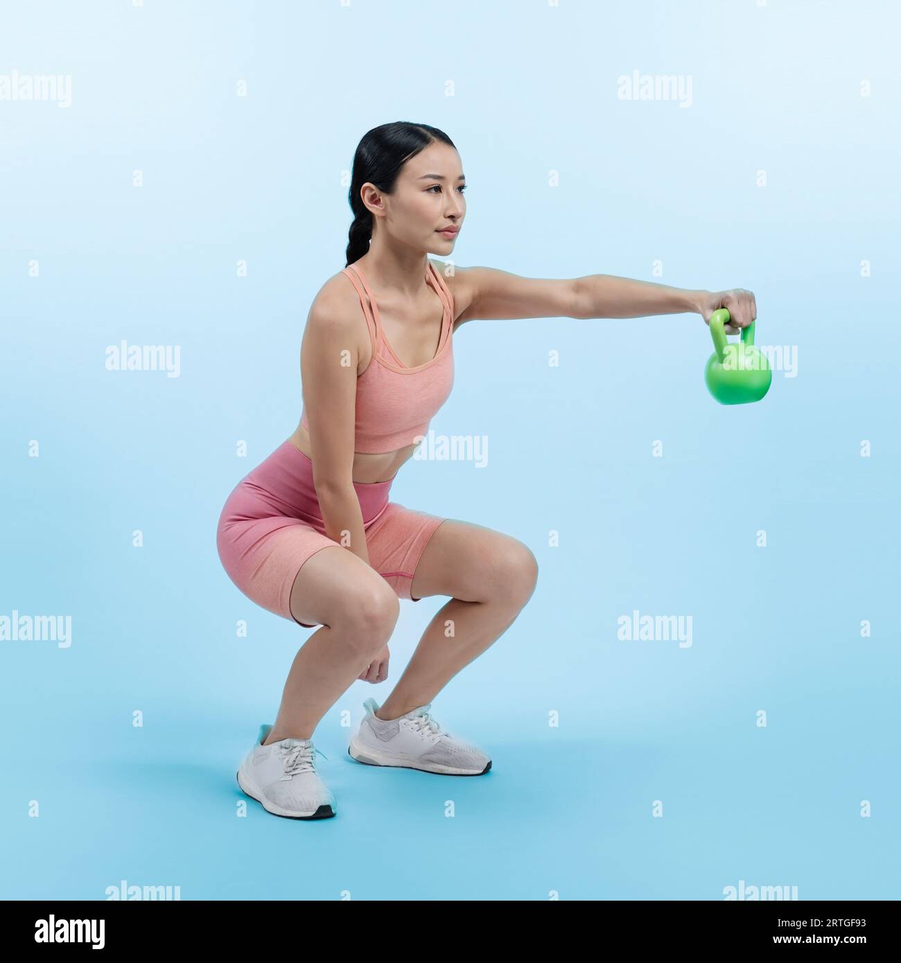 Vigorous energetic woman doing kettlebell weight lifting exercise on