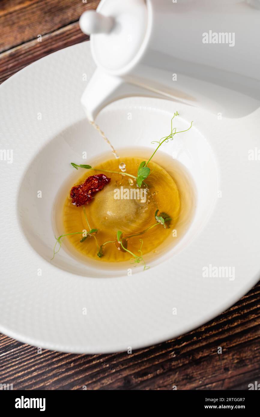 Ravioli consomme on a white porcelain plate. Healthy eating concept Stock Photo