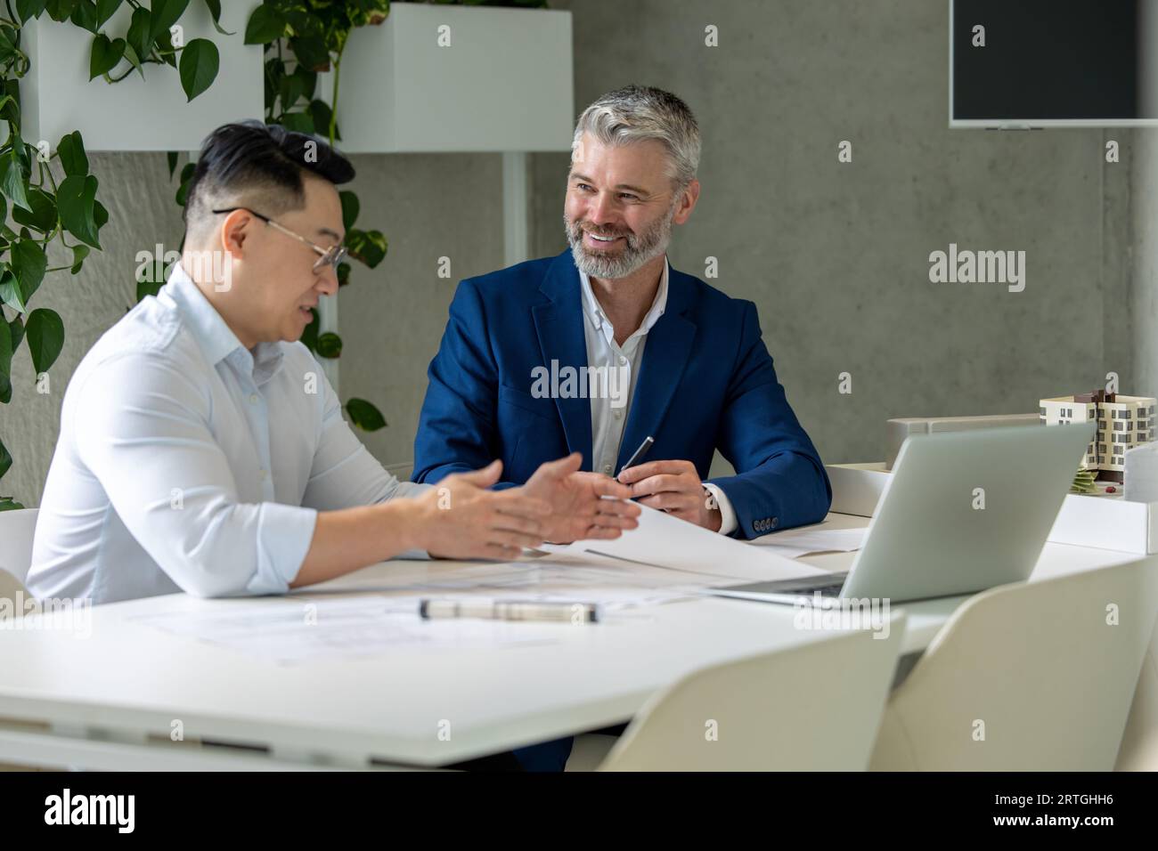 Men architects working on construction plans, engineers discussing on project in office. Stock Photo