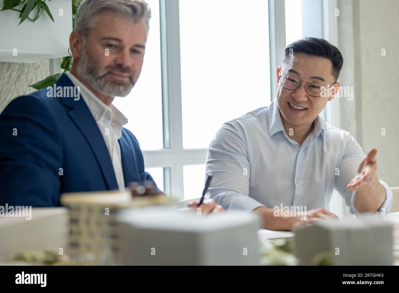 Men architects working on construction plans, engineers discussing on project in office. Stock Photo