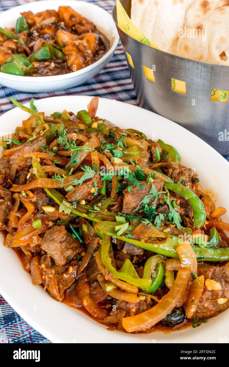 Close-up of Authentic Goan Beef chilly fry served with fresh soft naan. Tender boneless beef cubes stir fried with lots of onions and chillies. Stock Photo
