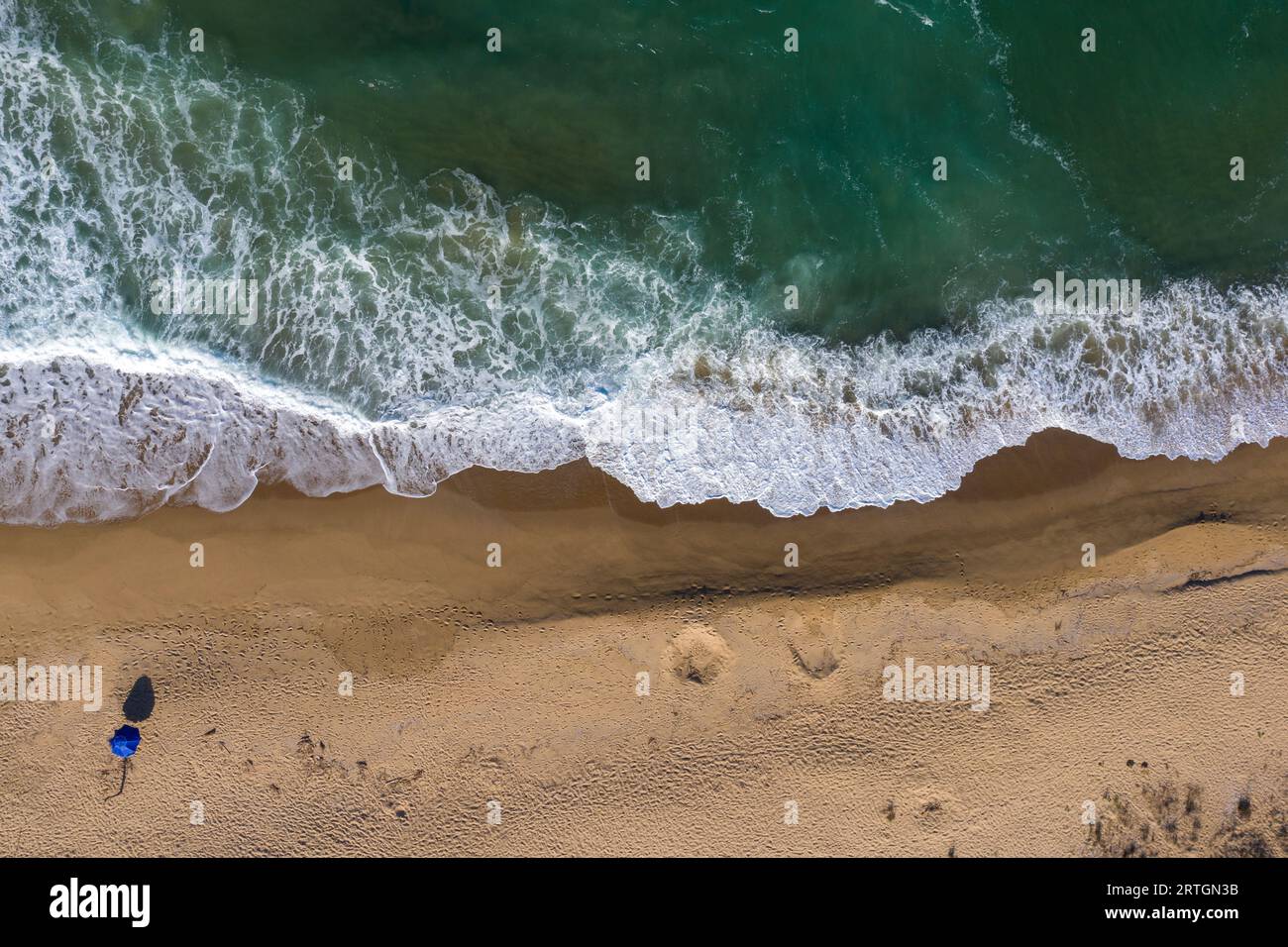 Aerial view of secluded beach with a single beach umbrella Stock Photo