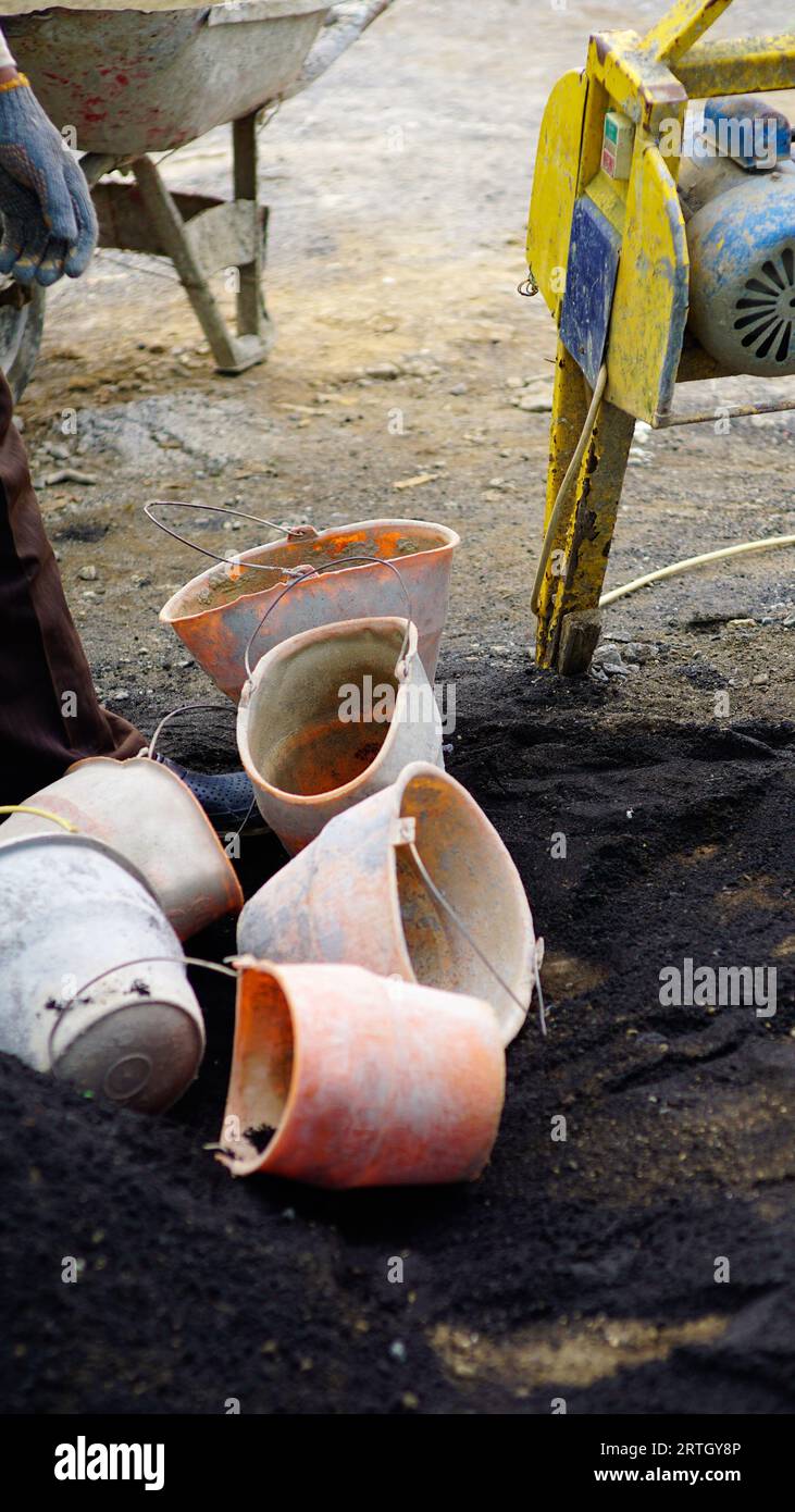 several plastic buckets in dirty conditions scattered around the workplace. Stock Photo