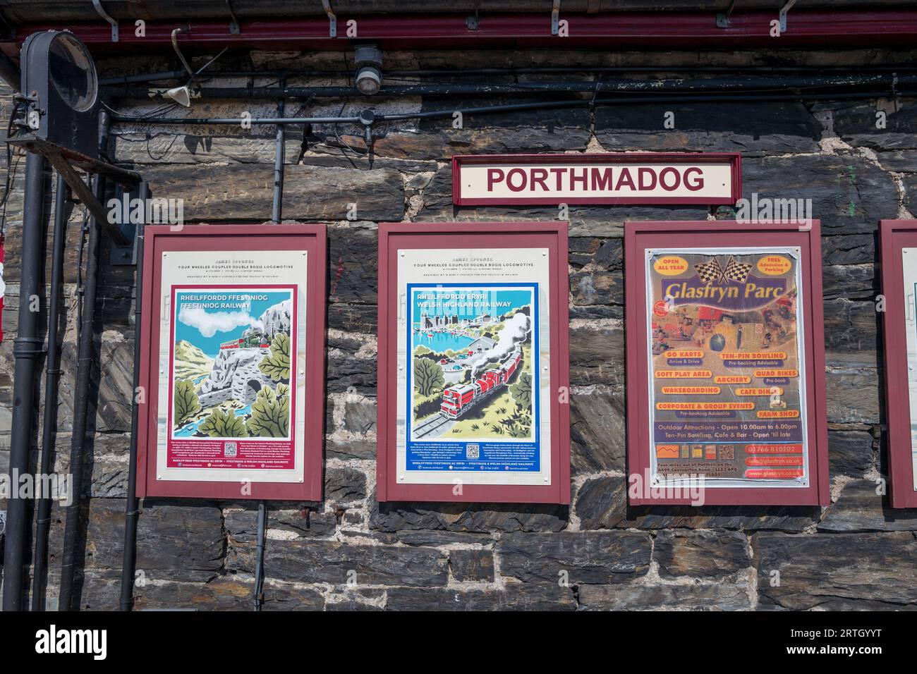Framed advertisment boards for the Ffestiniog and Welsh Highland railway train trips at the Porthmadoc railway station. Stock Photo